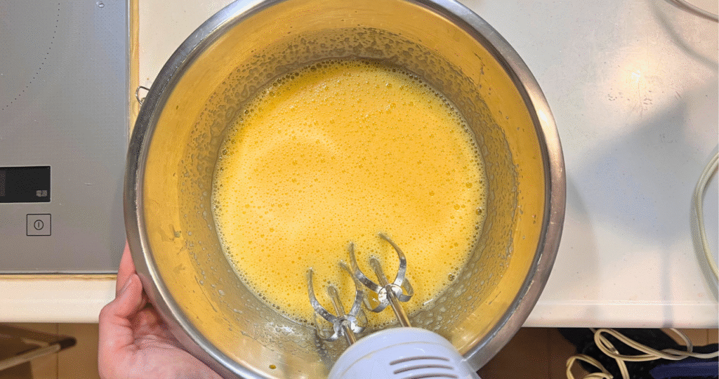 ボウルで卵と砂糖を混ぜている写真