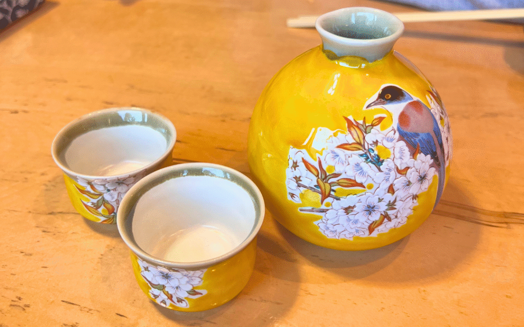 桜の絵柄が描かれた黄色い徳利とお猪口。友栄で提供される日本酒の器。
